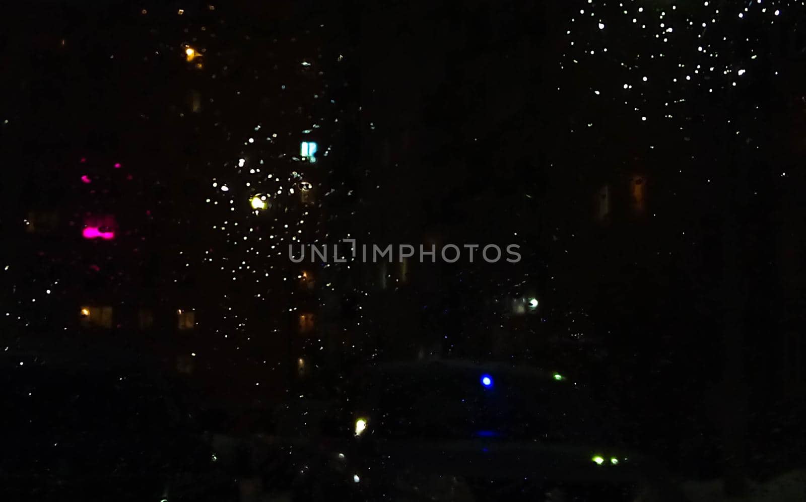 Reflection in a glass of glass. Blurred fires of distant houses. Window.