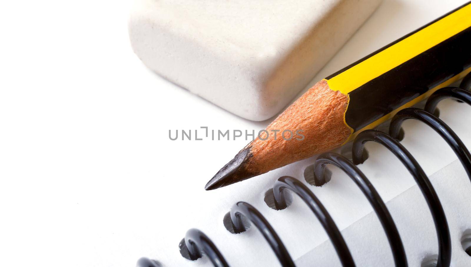 Pencil and eraser detail over white ring binder