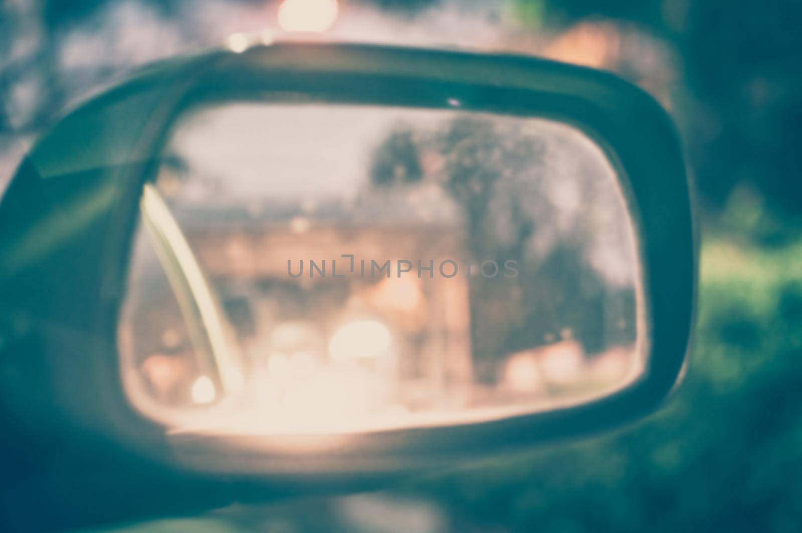 Vintage Style - blurred luxury car on road with side mirror.