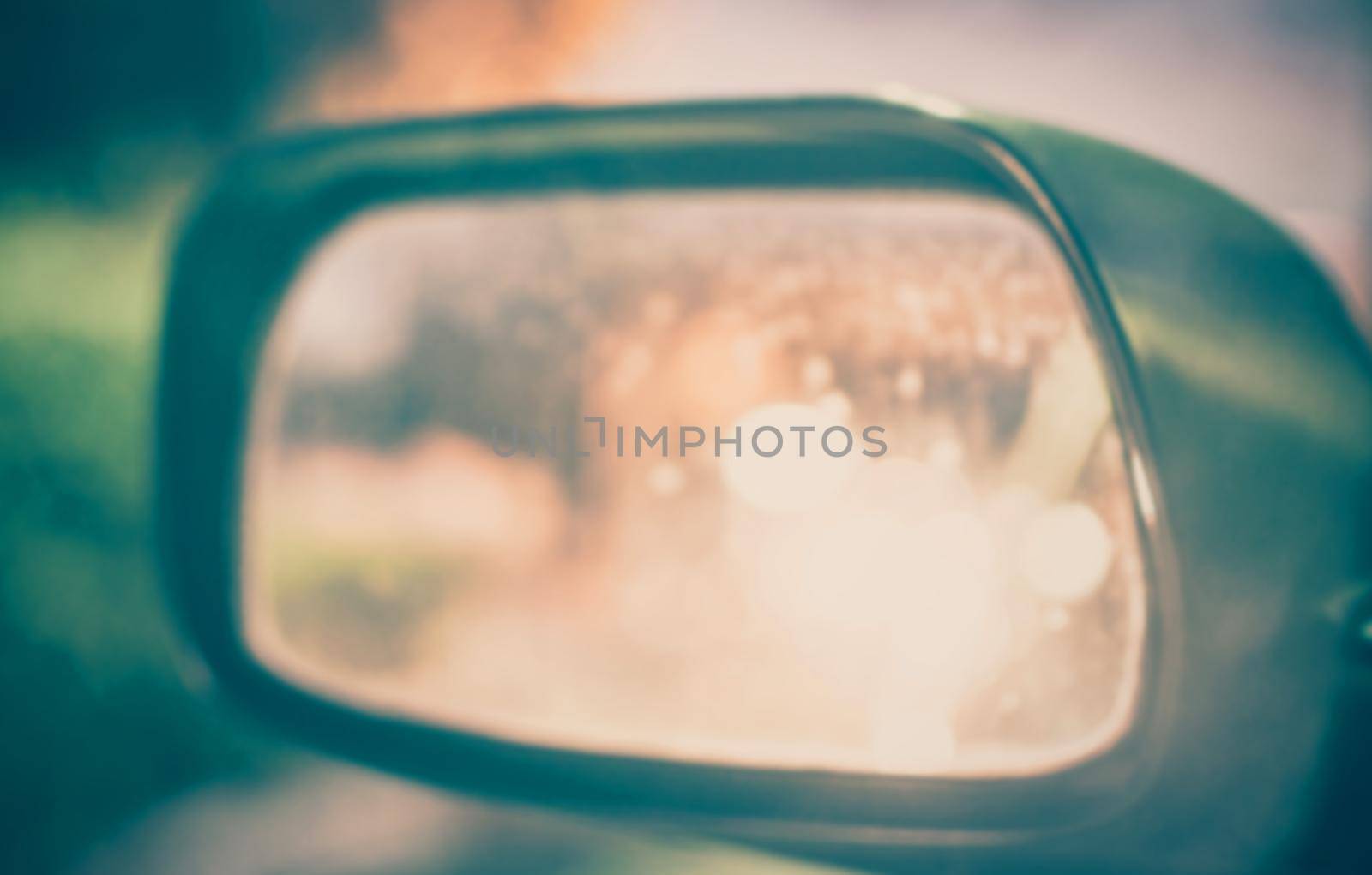 Vintage Style - blurred luxury car on road with side mirror.