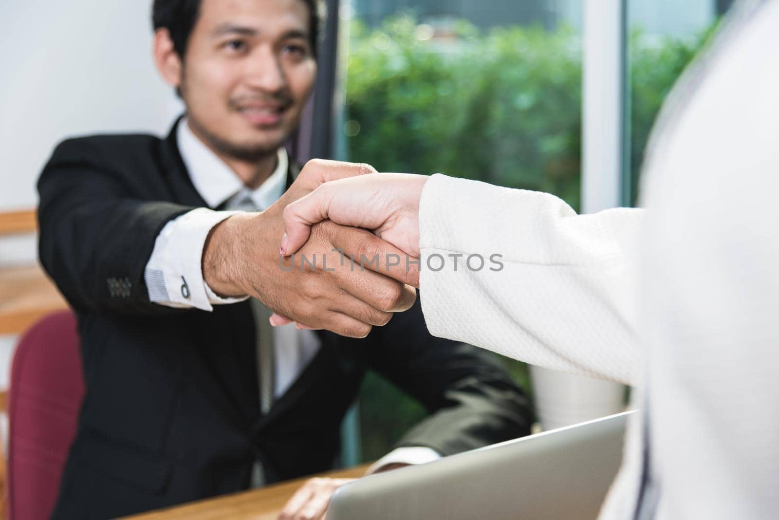 Businessman and Businesswomen shaking hands success meeting on desk in office