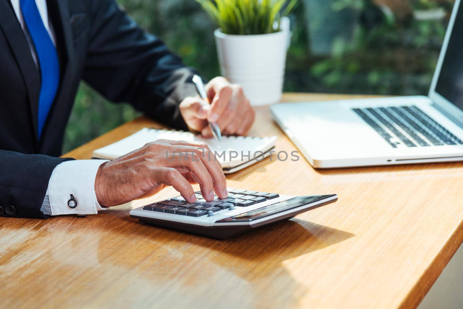 Business man accounting using calculating and work with laptop computer on desk office, finance concept