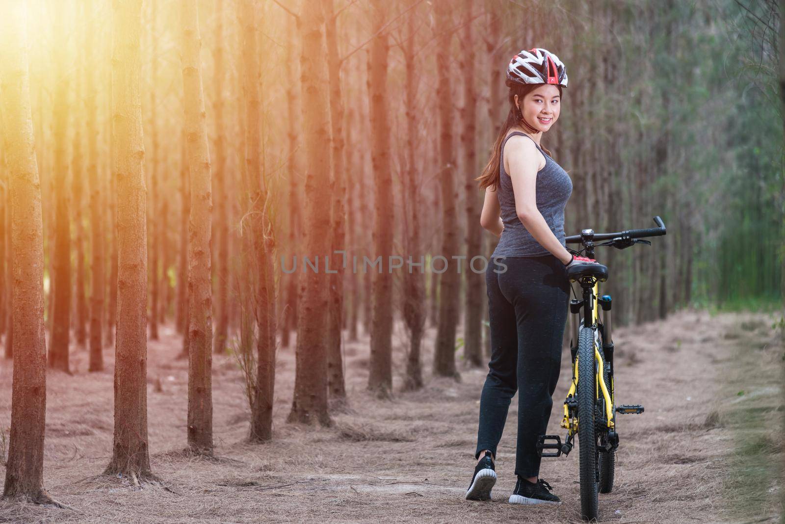 Back young female woman helmet catch bicycle by Sorapop