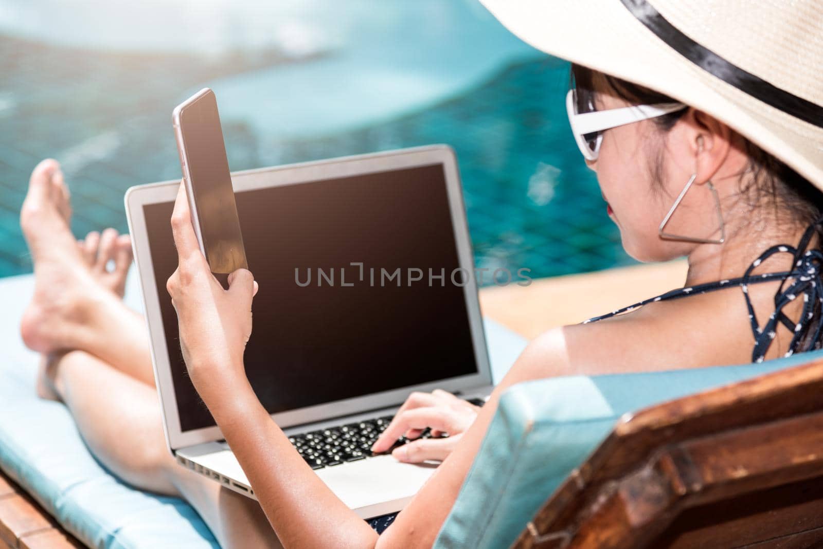Portrait Beautiful girl woman enjoying relaxing with mobile phone near swimming pool by Sorapop