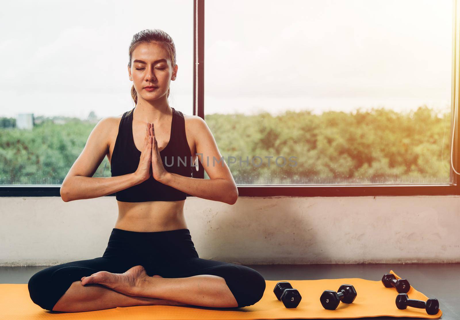 Beautiful woman sitting yoga raise hand before exercise workout on mat by Sorapop