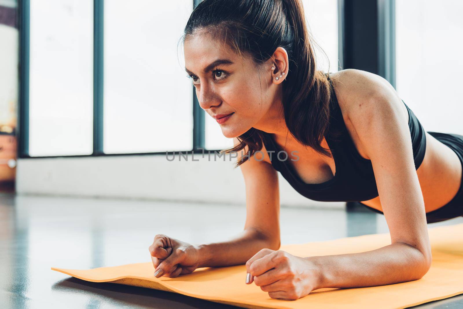 Beautiful woman exercise workout with planking on mat at fitness GYM