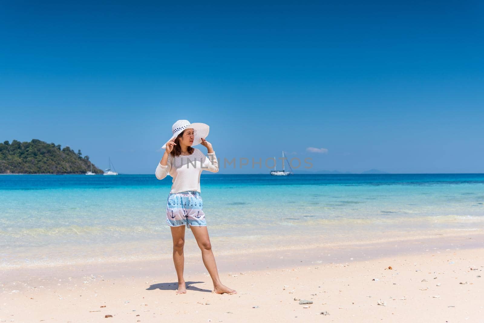 Happy young woman enjoying on beach by Sorapop