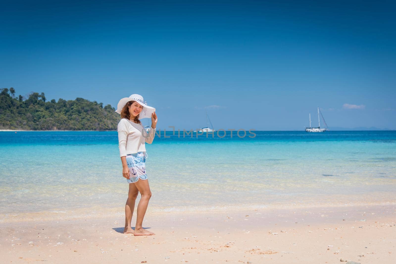 Happy young woman enjoying on beach by Sorapop