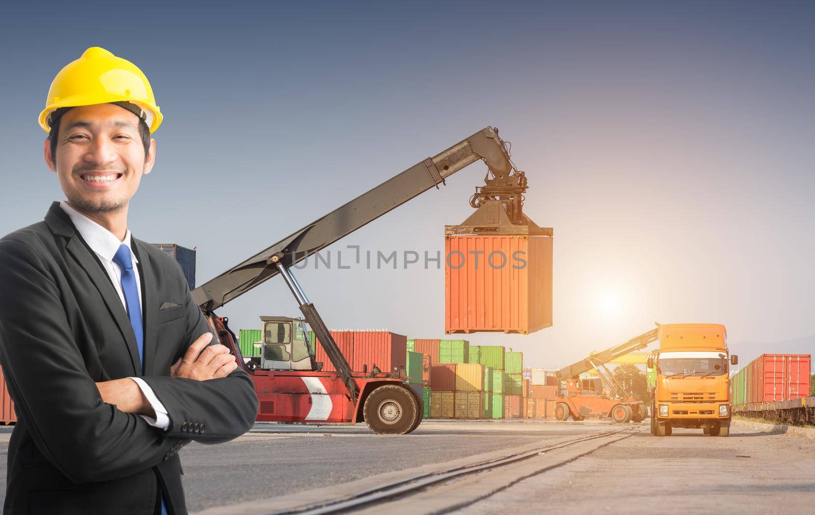 Businessman stand on front forklift loading Containers box by Sorapop