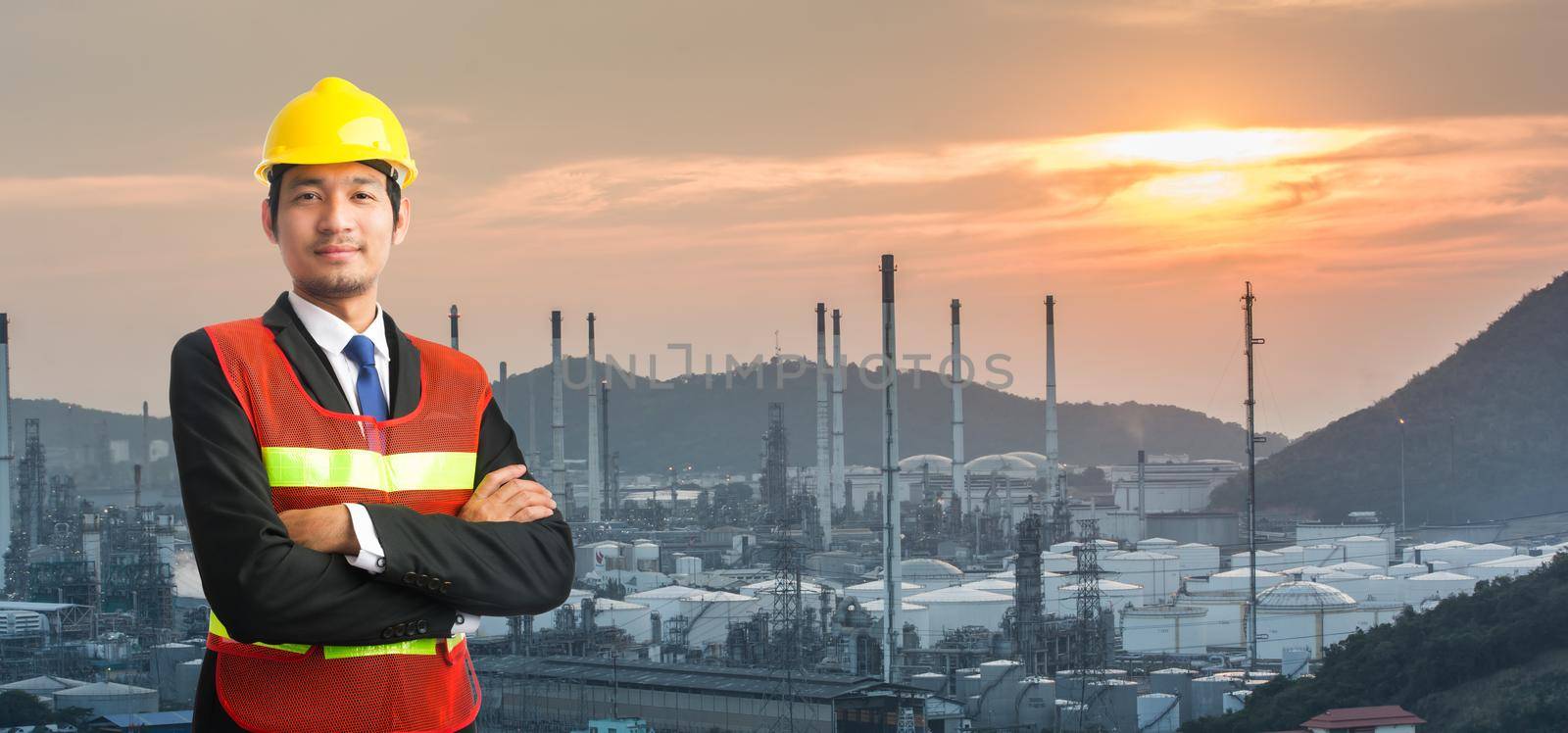 engineering man and safety helmet, shirts standing arms crossed against oil refinery plant in petrochemical industr