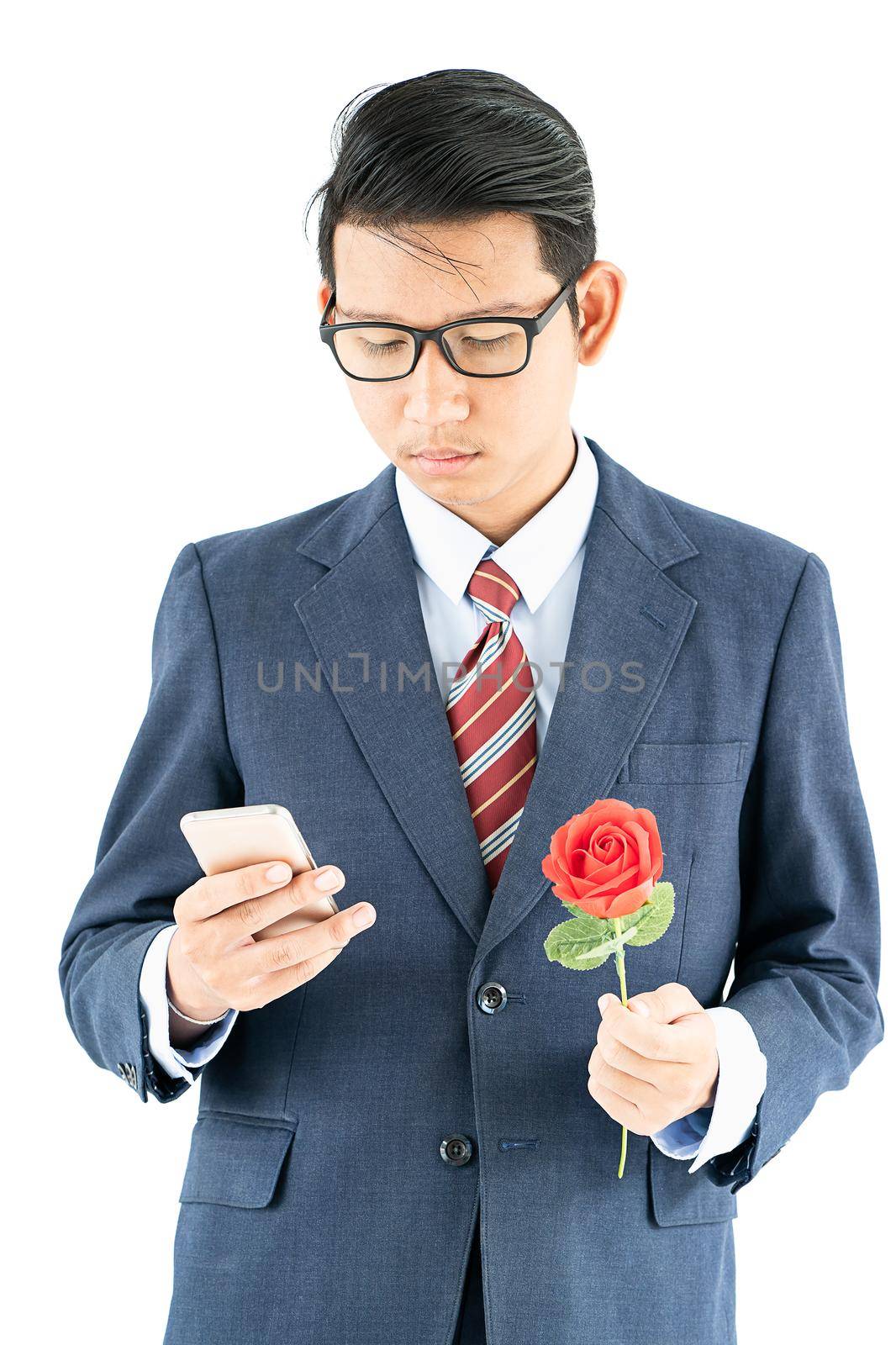 Close up photo of businessman in suit holding smartphone and red rose on white background