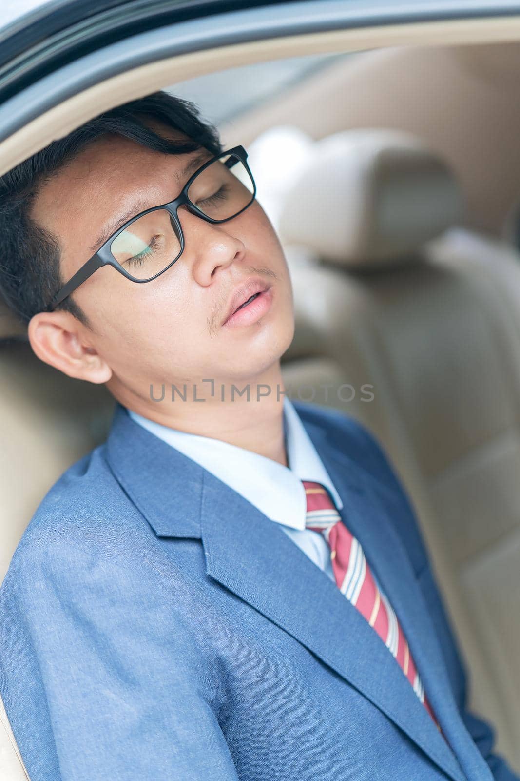 Young asian business men portrait in suit sit in the backseat of a car