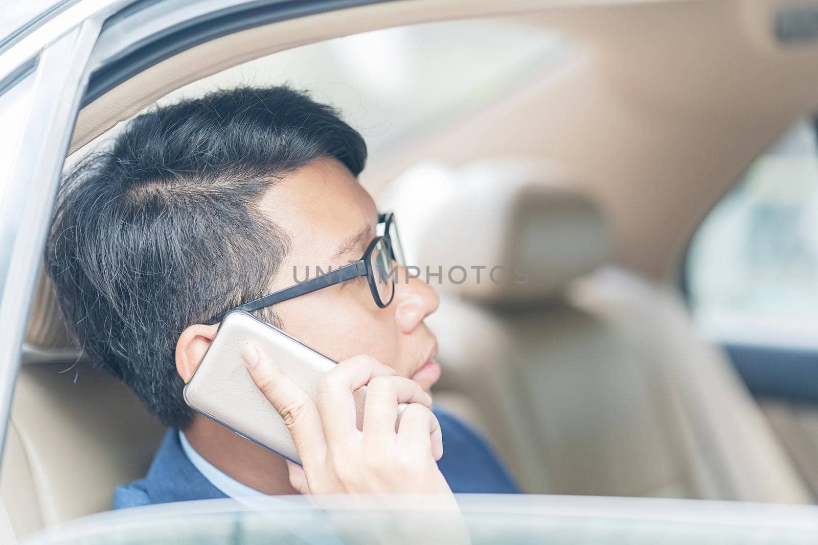 Businessman working in backseat of a car  by stoonn