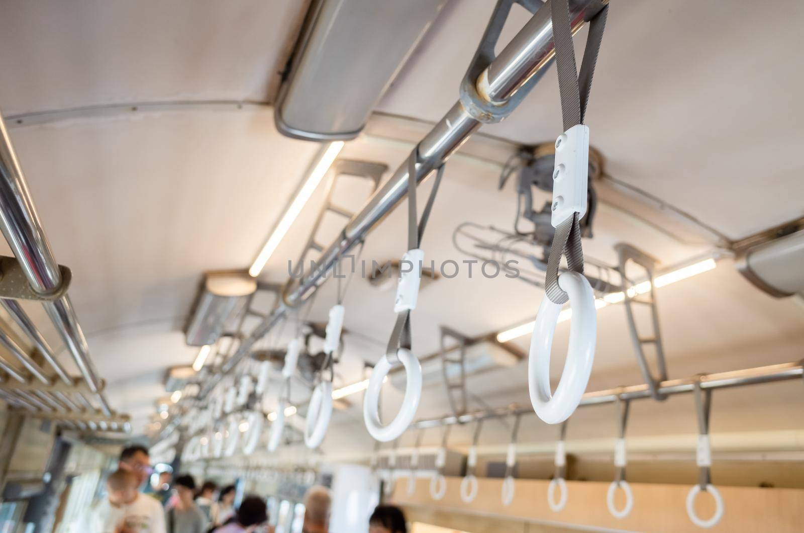 white handle on the ceiling for standing passenger