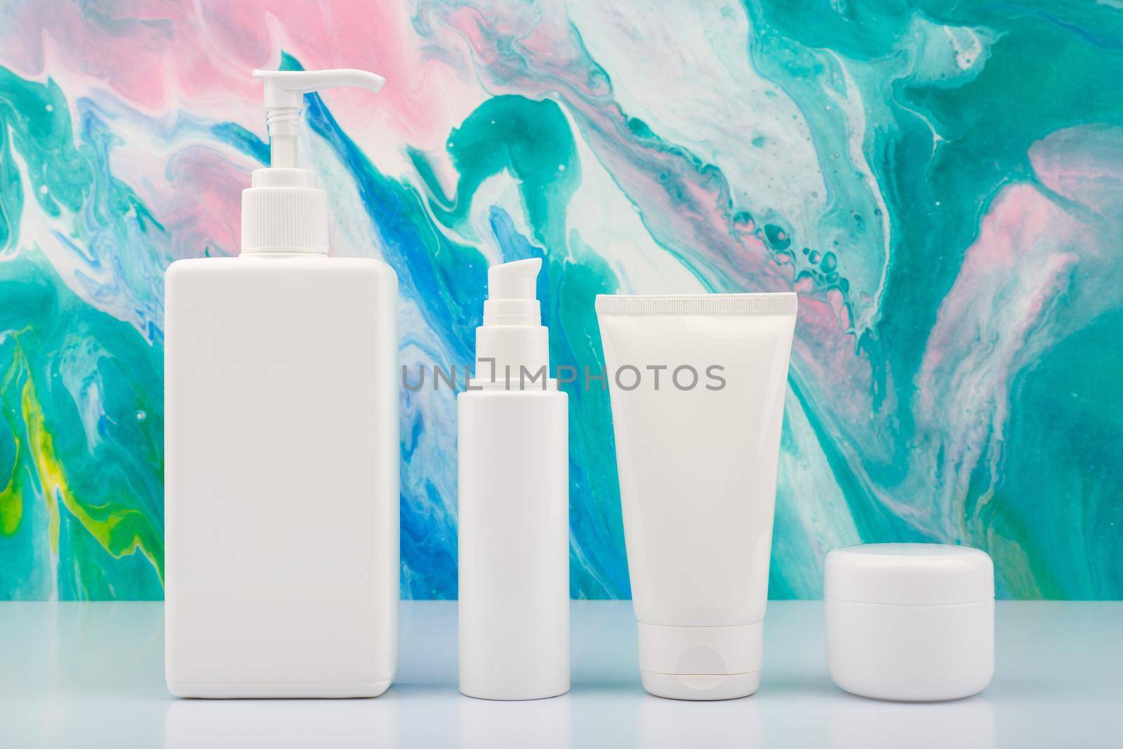 Body cream, face cream, face lotion and under eye cream on white table against blue marbled background by Senorina_Irina