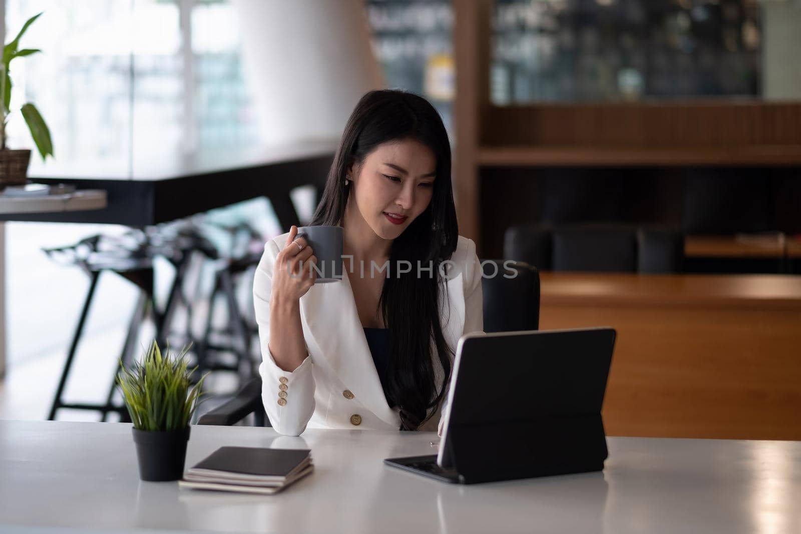 Shot of an attractive young businesswoman working on laptop in her workstation by nateemee