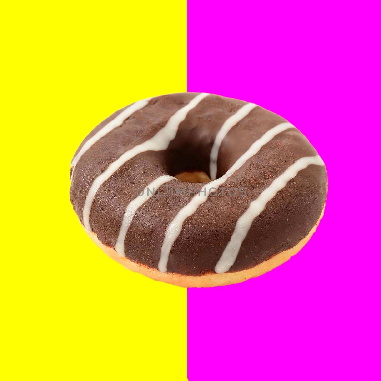 One whole chocolate donut isolated over half pink and half yellow background, retro vintage styled image.