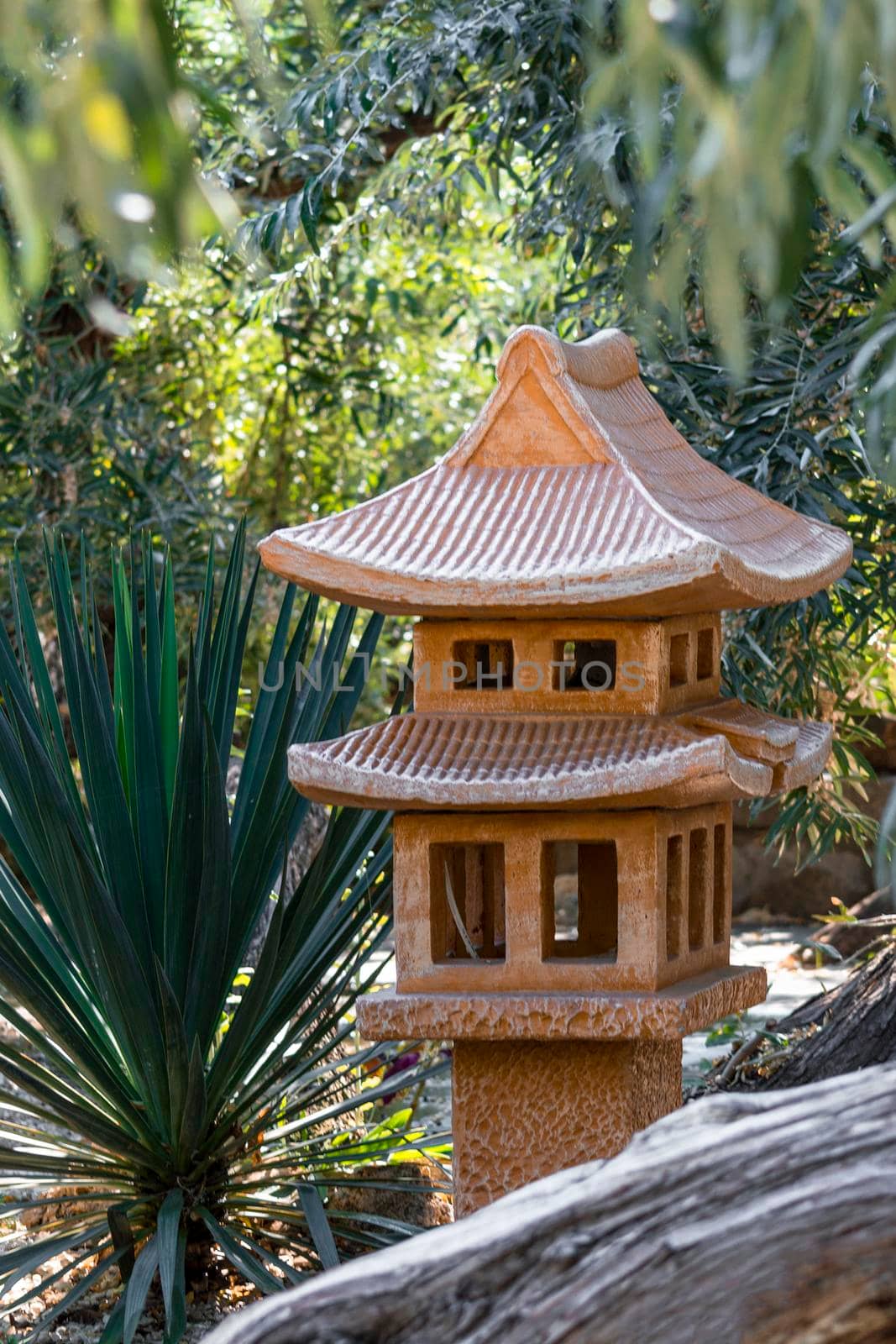 Decorative pagoda house in the garden. Sunny summer day. Front view. by Essffes