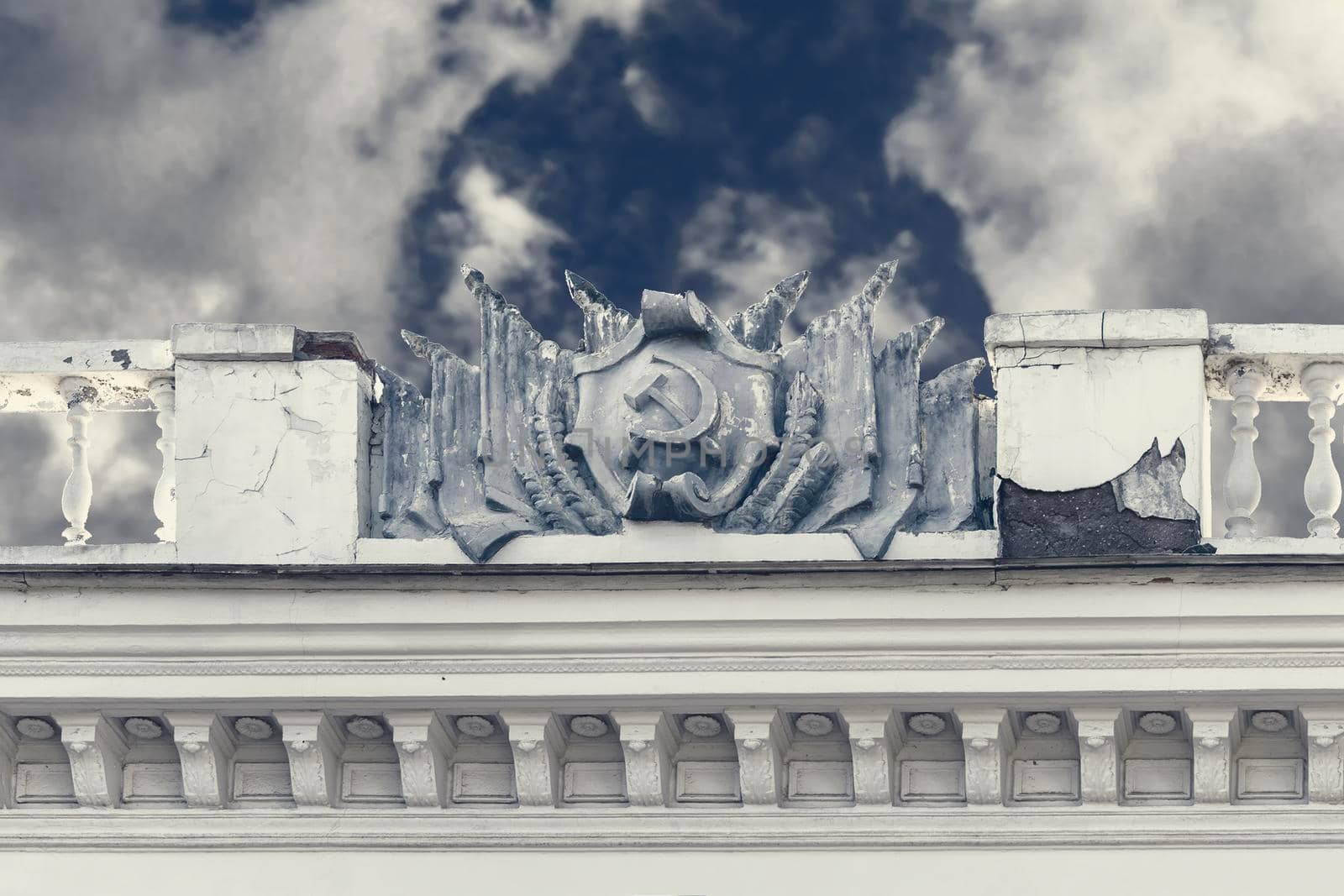 Coat of arms and flags of USSR of plaster on facade of old building. Crimea, Sudak - 10 October 2020. by Essffes