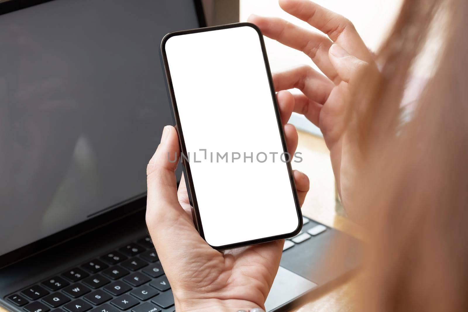 Top view of woman hand using smartphone with blank white screen.