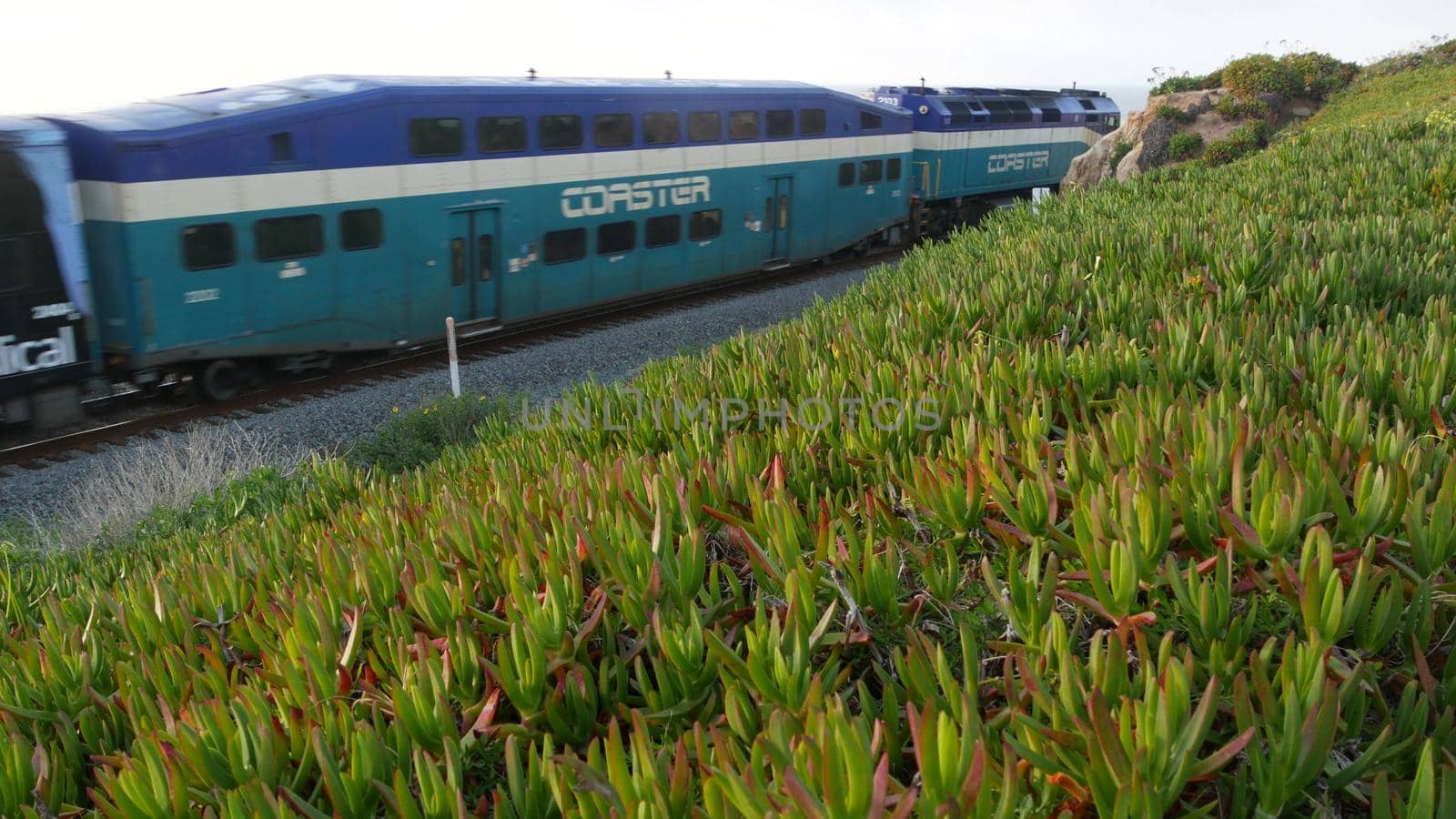 Del Mar, California USA - 23 Jan 2020: Coaster train, travel along pacific ocean beach. Passenger railroad, public transit. Express rapid intercity double decker blue commuter. NCTD railway transport.