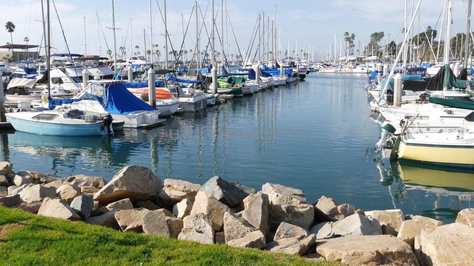Oceanside, California USA - 27 Jan 2020: Waterfront harbor fisherman village, luxury yachts sailboats floating, marina harbour quay. Sail boat masts, nautical vessels anchored or moored in port.