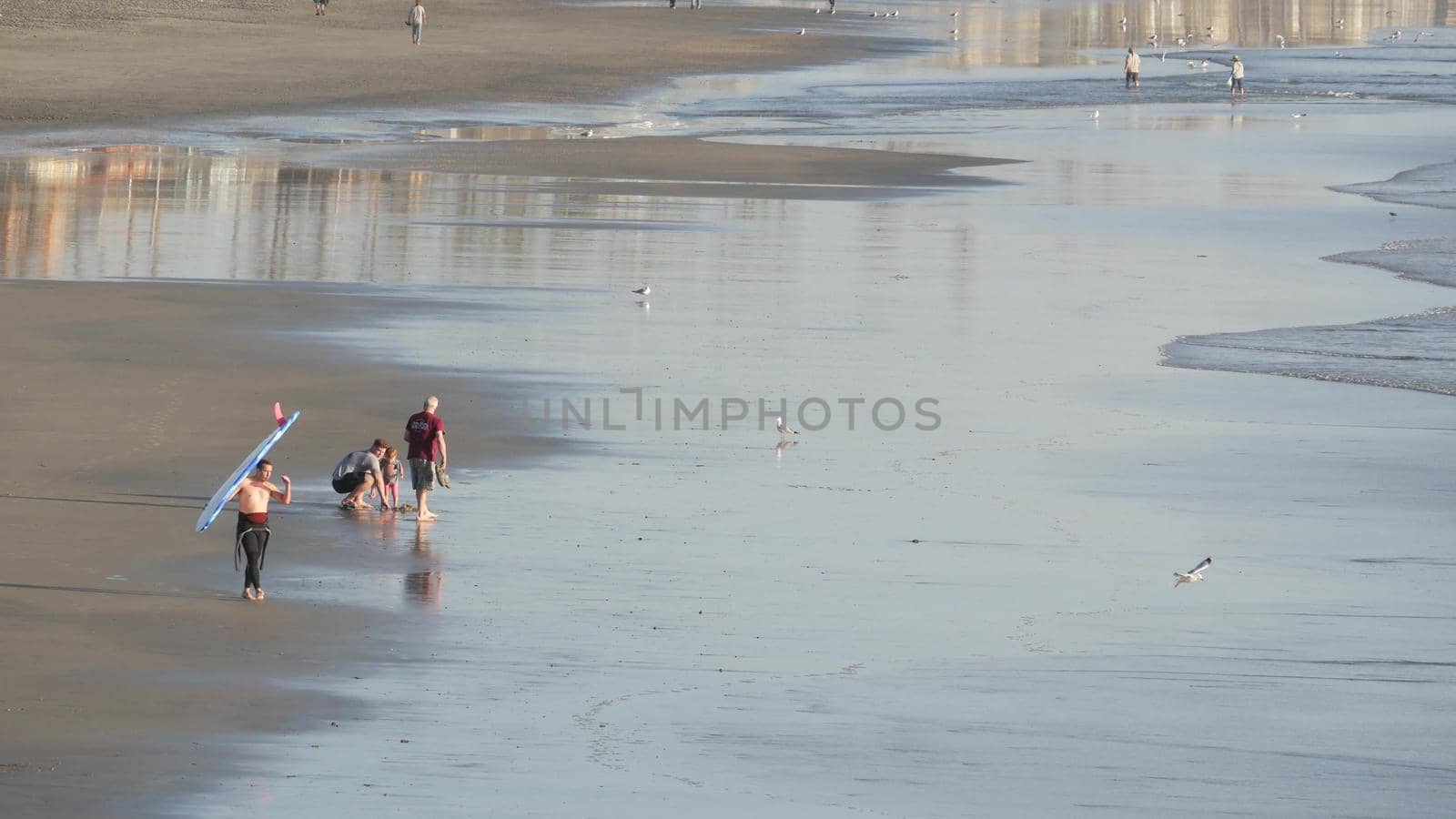 People walking strolling. Pacific ocean, sea water wave. Beachfront vacations resort. California USA by DogoraSun