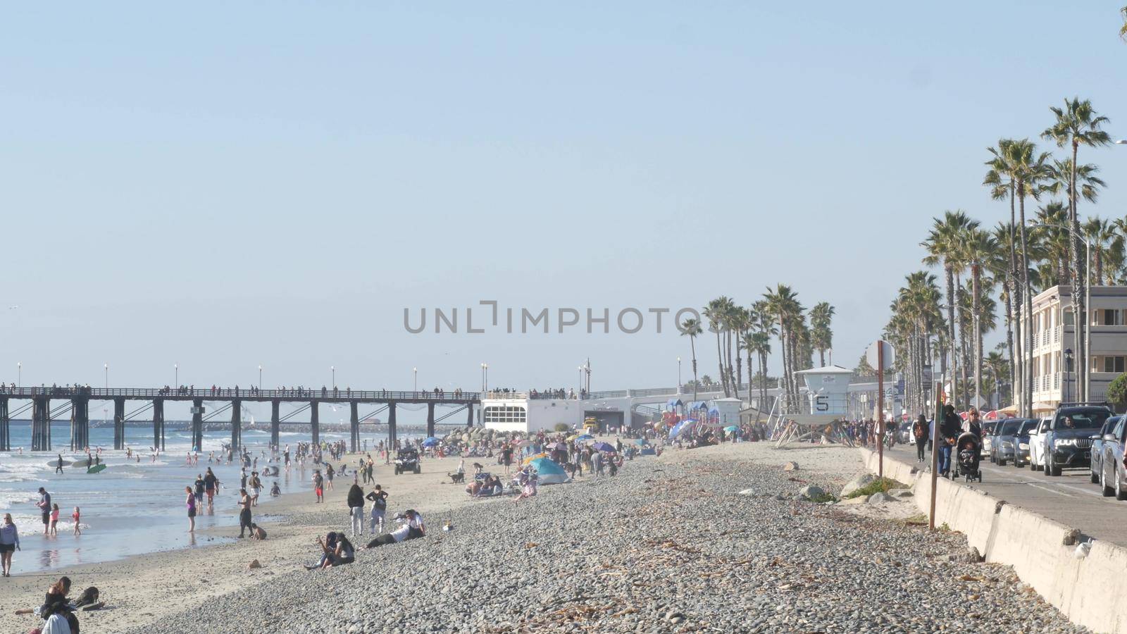 People walking, waterfront promenade beachfront boardwalk. Ocean beach near Los Angeles, California USA by DogoraSun