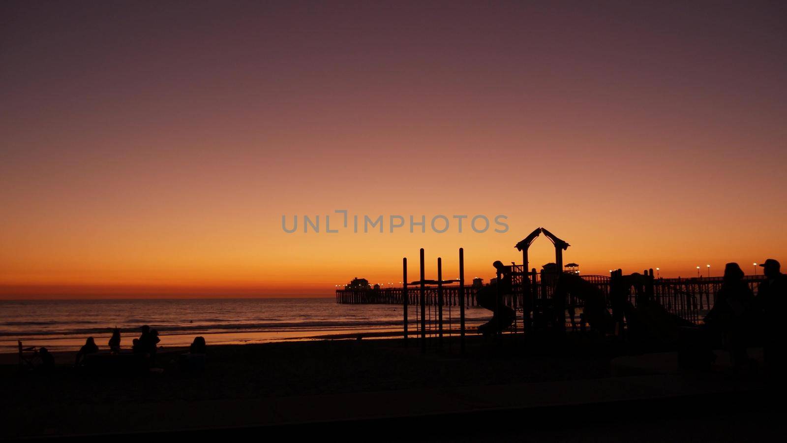 People making bbq campfire. Beachfront recreation area for barbeque with fire place. California USA. by DogoraSun