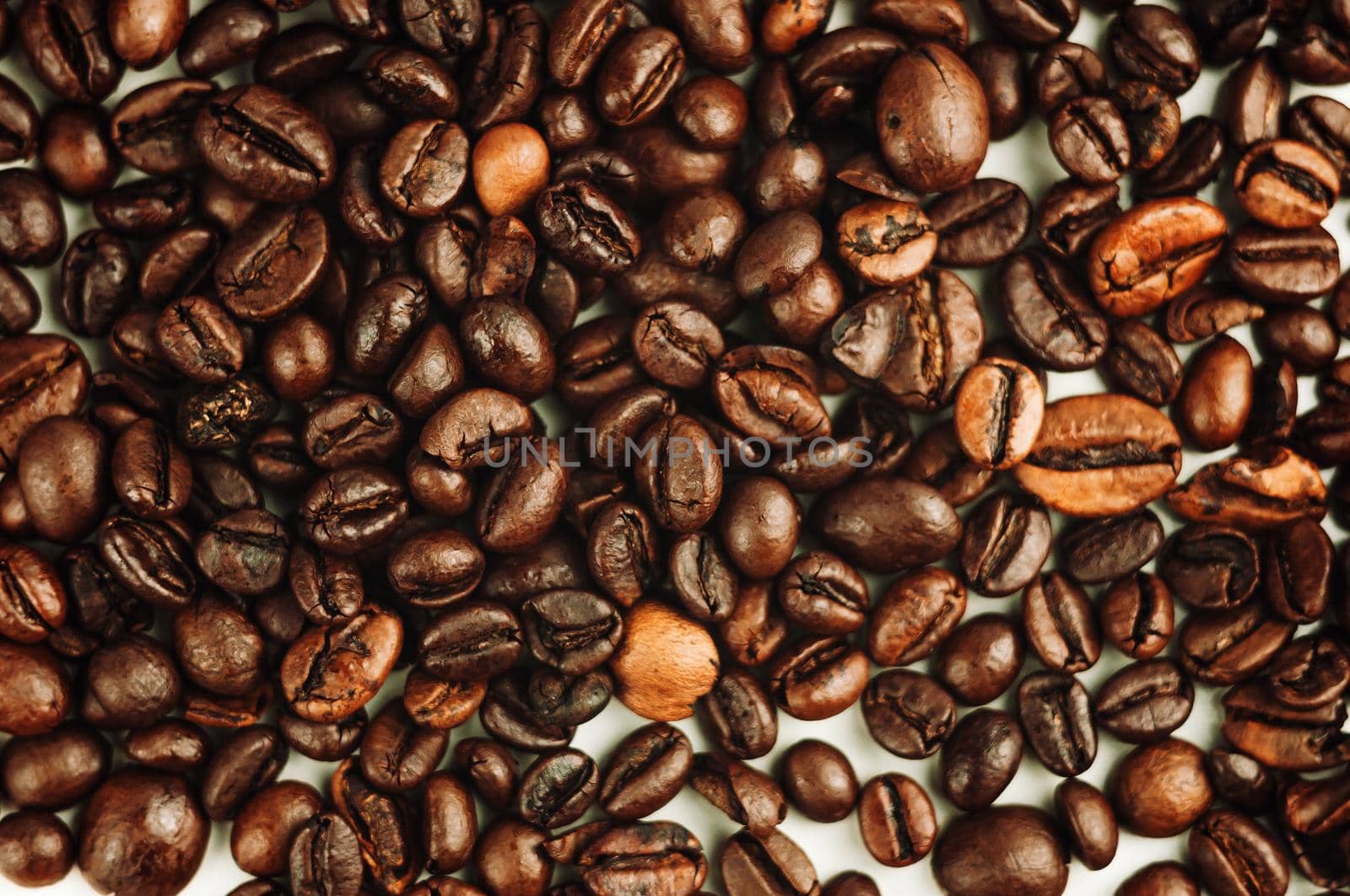 Dark roasted coffee beans background. Grains are prepared according to the method of roasting with the release of oil for the aroma of the drink.