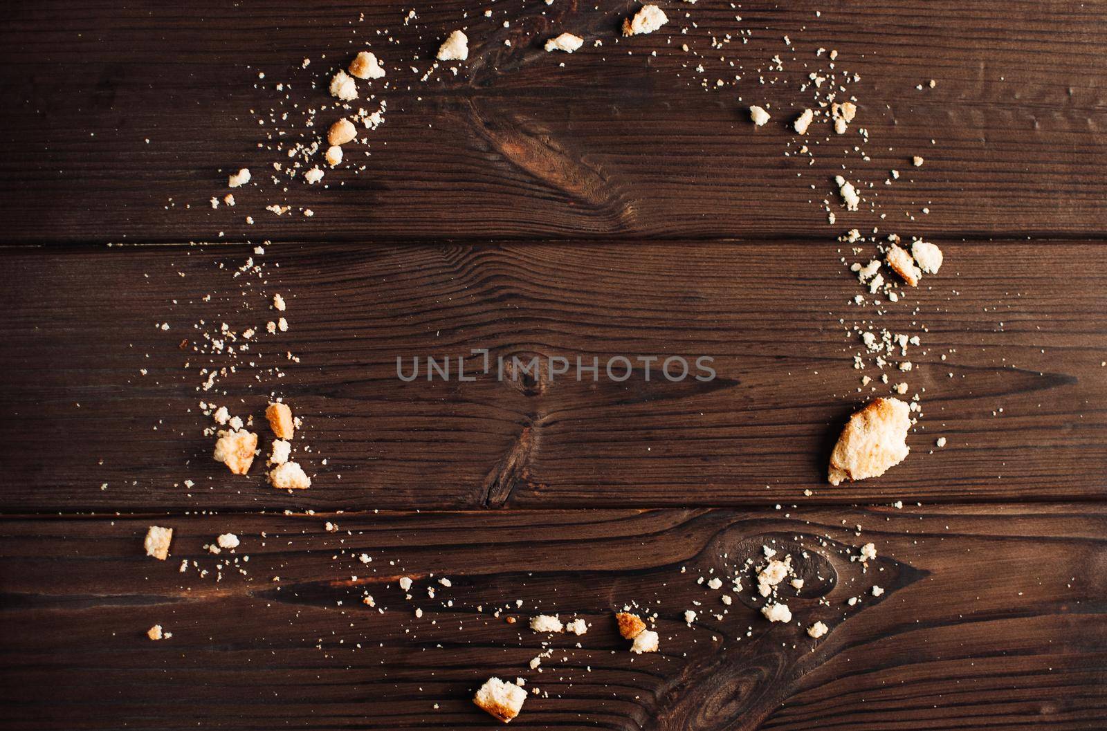 Crumbs from chocolate cookies on a wooden table background. Copyspace