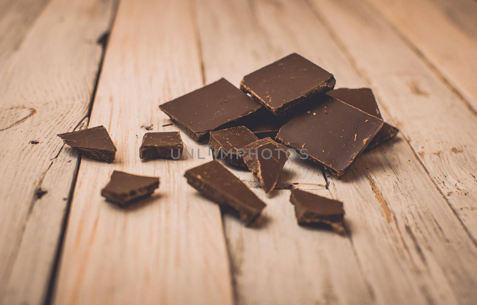 dark chocolate without sugar and gluten free for diabetics and allergics. Black chocolate broken into pieces ice on a white table in a rustic style.