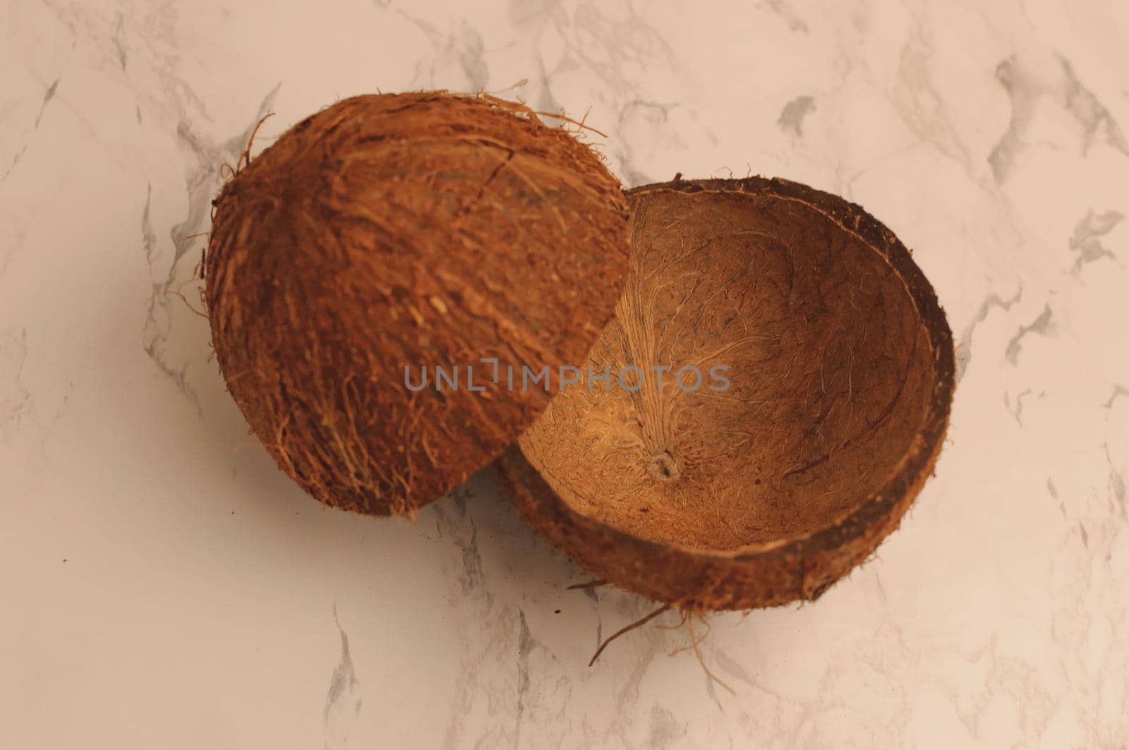 two halves of a coconut shell on a marble background, isolate. Future food bowls zero waste. Environmentally friendly material for utensils. Copy space.