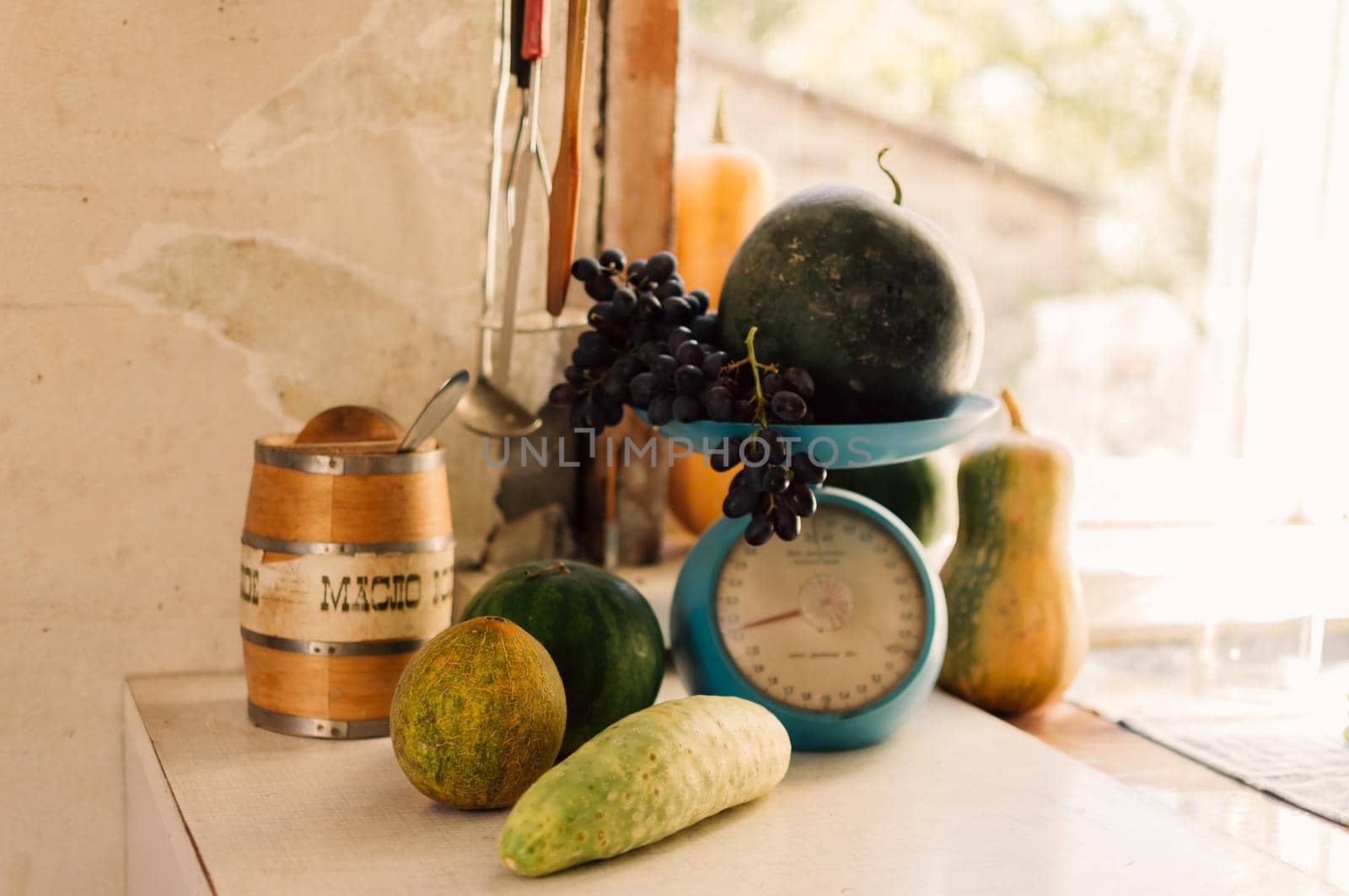 Autumn still life with pumpkins,zucchini,melons,watermelon and grapes on scale to scale and on a wooden white table.Autumn harvest concept. Happy Thanksgiving. Selective focus. Horizontal orientation.