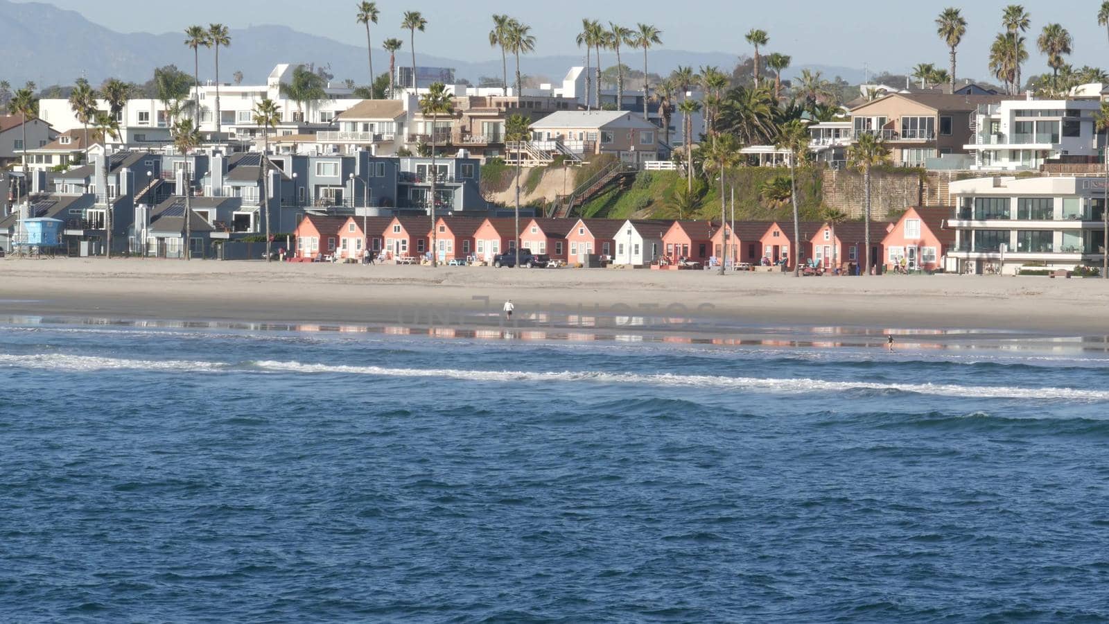 People walking strolling. Pacific ocean, sea water wave. Beachfront vacations resort. California USA by DogoraSun