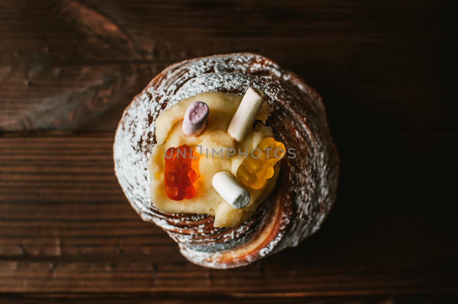 Stylish Easter cake with marshmallows and jelly bears on a dark rustic wooden background, Seasonal greetings for Easter. Copy space. view from above.