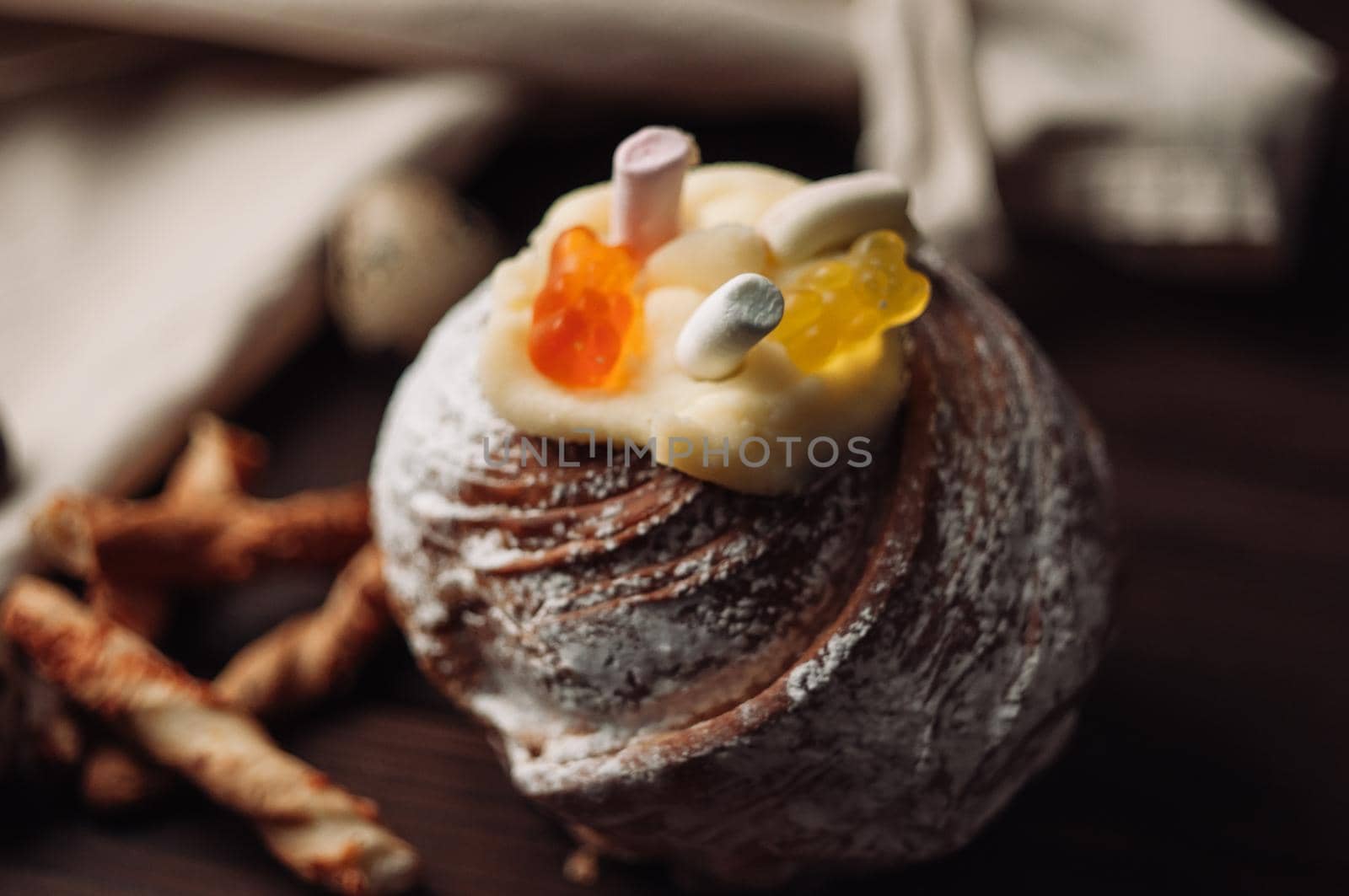 Stylish Easter cake with marshmallows and jelly bears on a dark rustic wooden background. Seasonal Happy Easter greetings. selective focus. modern happy easter image