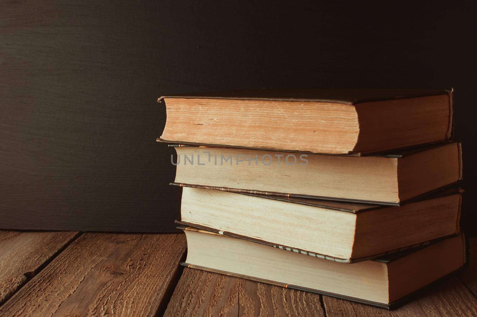 books stacked on a wooden table in a rustic style on the background a school blackboard. The concept of welcome back to school. copy space by Alla_Morozova93