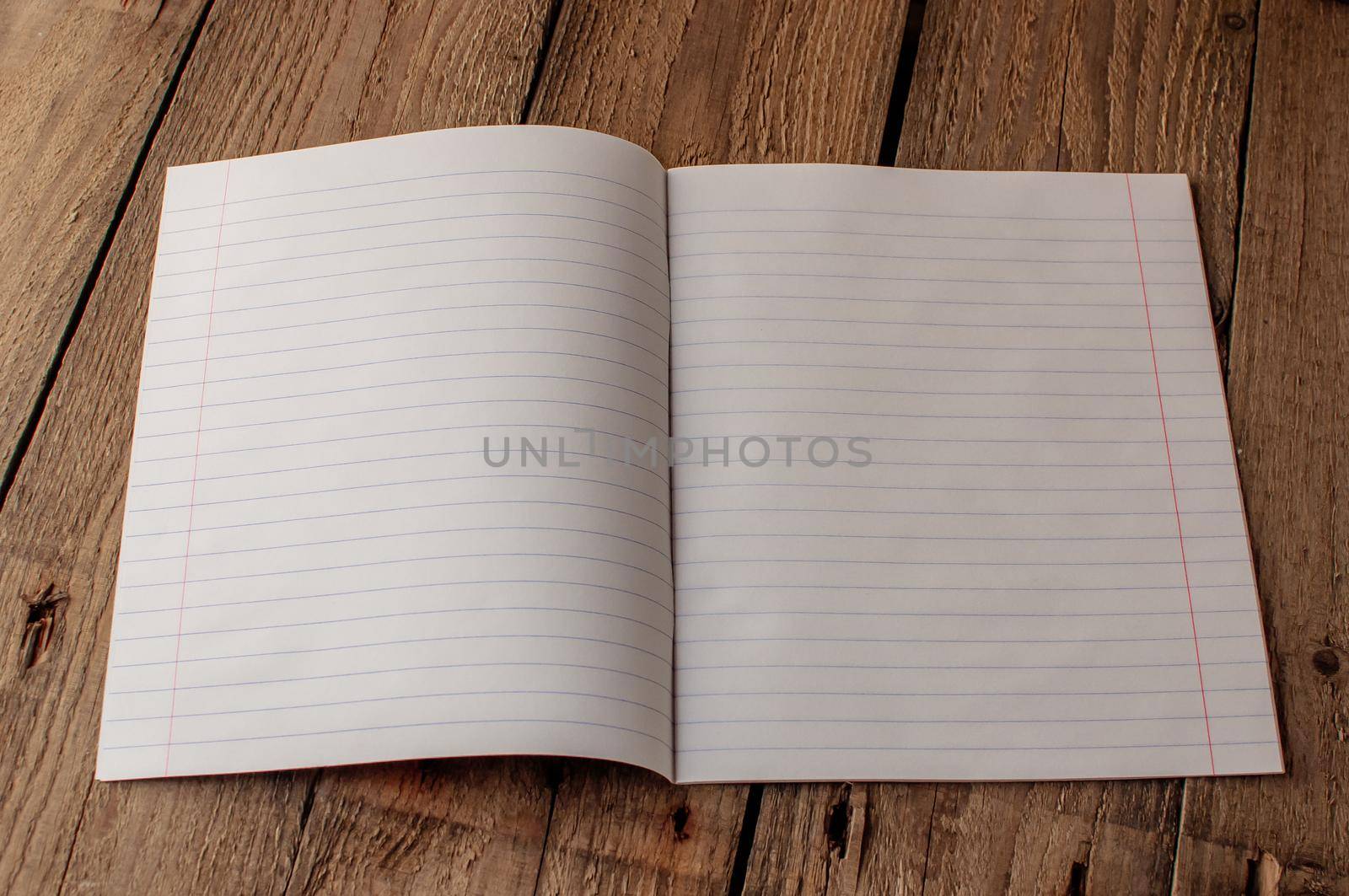 Back to school, the concept of raising children. Day of knowledge. Notebook in line on a wooden table with space for text. Save space. Rustic and vintage toning.