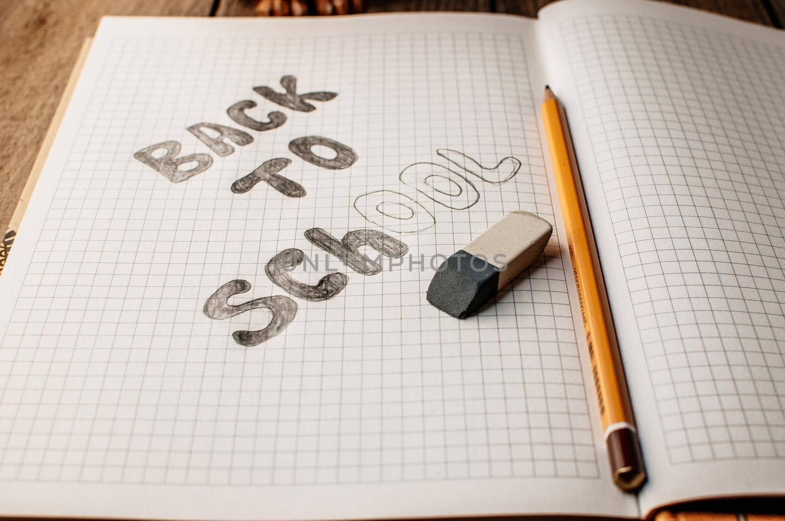 Back to school, the concept of raising children. Day of knowledge. Notebook in a slanting line on a wooden table with space for text. Save space. Rustic and vintage toning.