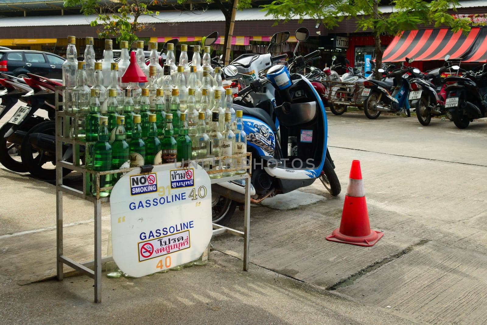 2019-11-05 / Phuket, Thailand - Bottles of gasoline for sale in a motorcycle rental stand.