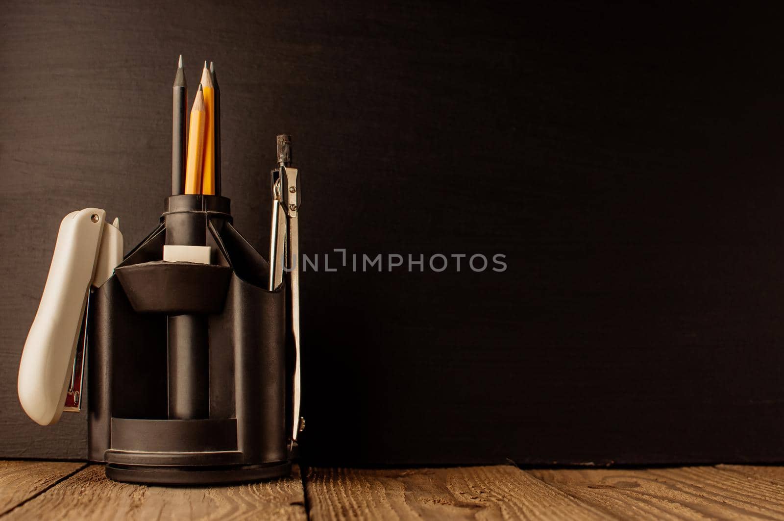 Back to school, the concept of parenting. An assortment of consumables, stands for pens and pencils, an eraser, stationery knives, compasses.Education concept.Copy space. Rustic and vintage toning.