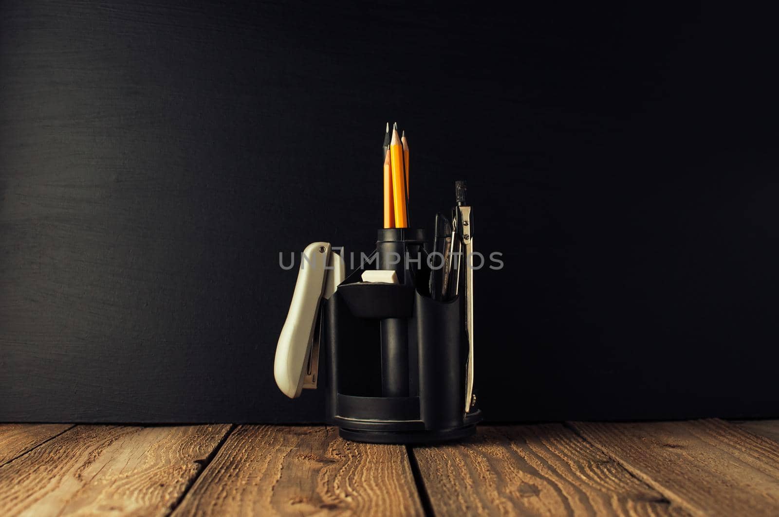 Back to school, the concept of parenting. An assortment of consumables, stands for pens and pencils, an eraser, stationery knives, compasses.Education concept.Copy space. Rustic and vintage toning.