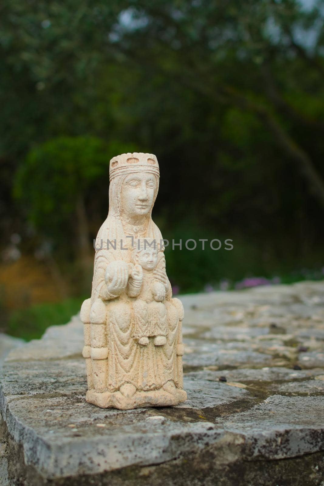 Small medieval sculpture of Virgin Mary holding a baby Jesus Christ. Early medieval style replica.