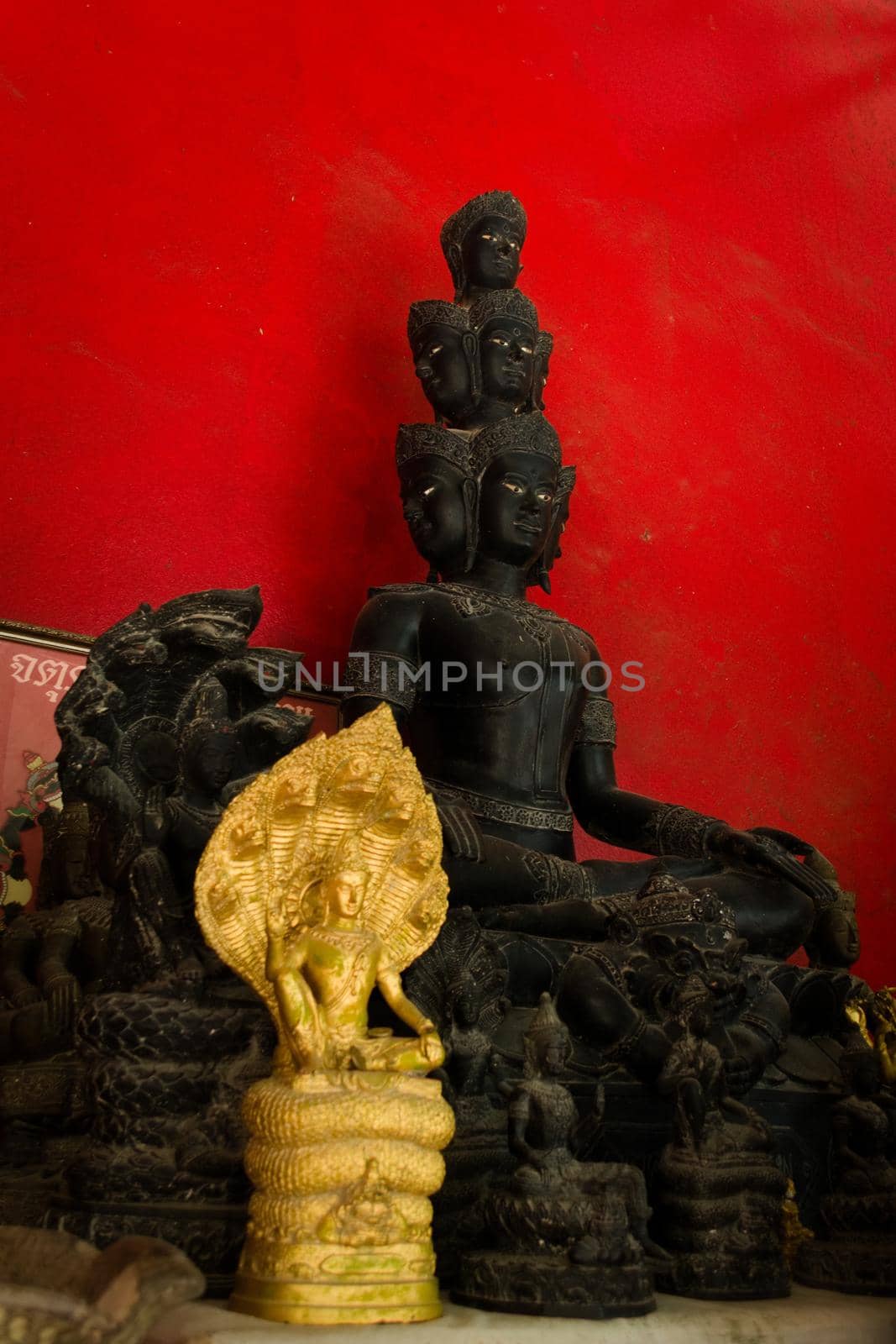 Statue of a buddhist asura, a demigod with many faces, on display in a temple in Phuket, Thailand. by hernan_hyper