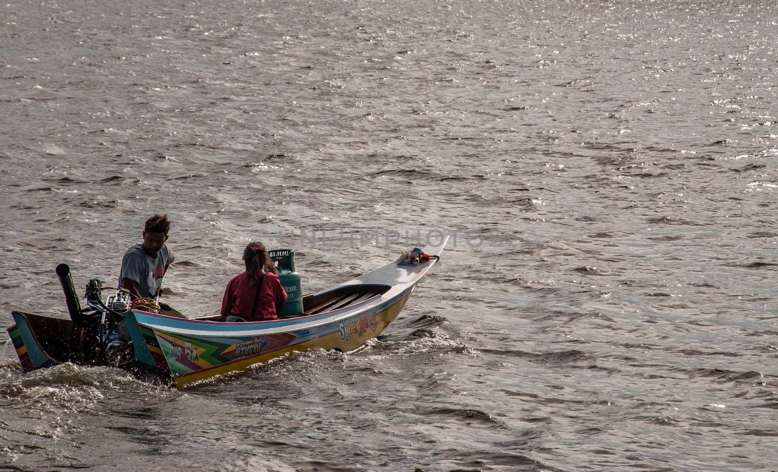 Bangkok, Thailand - 21 Jul 2019 : Long-tailed  boat rushing on water surface against of Chao Phraya to send passengers across the ferry.