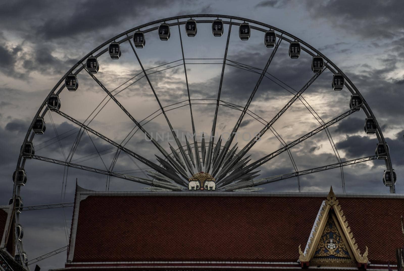 Bangkok, thailand 21 Jul, 2019 : The roof of the Wat Ratcha Singkhon with Asiatique Ferris Wheel and Blue Sky at a backdrop.