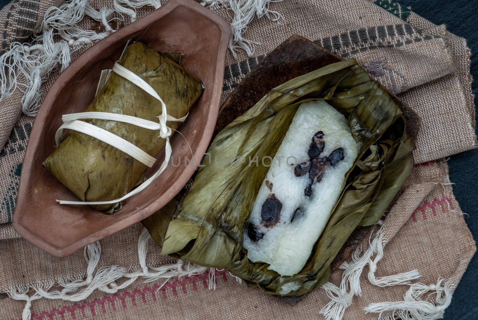 Khao tom mat, a Laotian and Thai dessert of seasoned steamed sticky rice wrapped in banana leaves normally inserted with filling made of banana and black beans for special occasions or merit making, Steamed mung bean with sticky rice. Top view.
