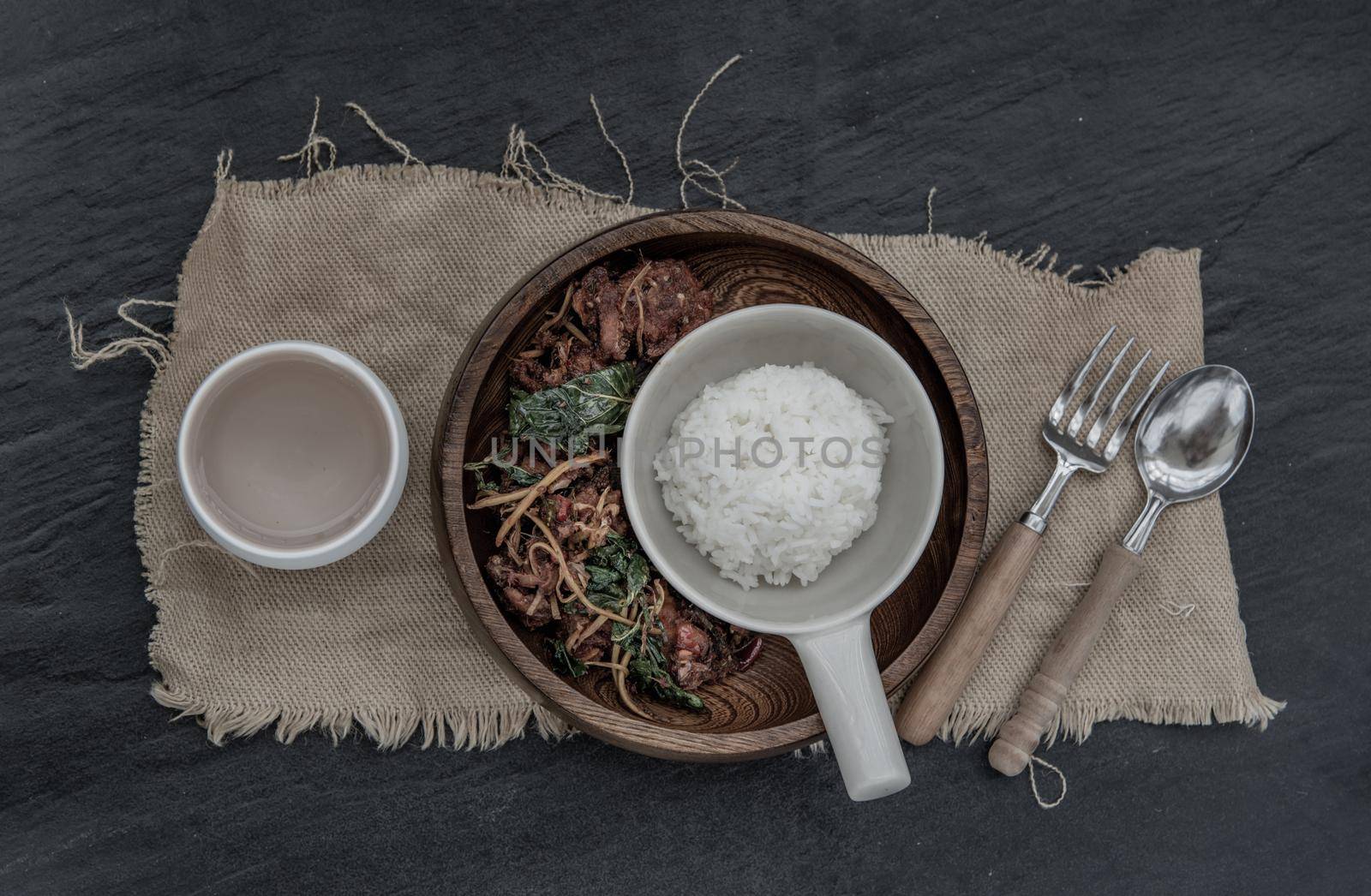 Thai Spicy food, Spicy Stir Fried Deep Fish Fillet with Herbs vegetables served with steamed rice in wooden bowl : in Thai language called "Pad Cha " Top view, Selective focus.