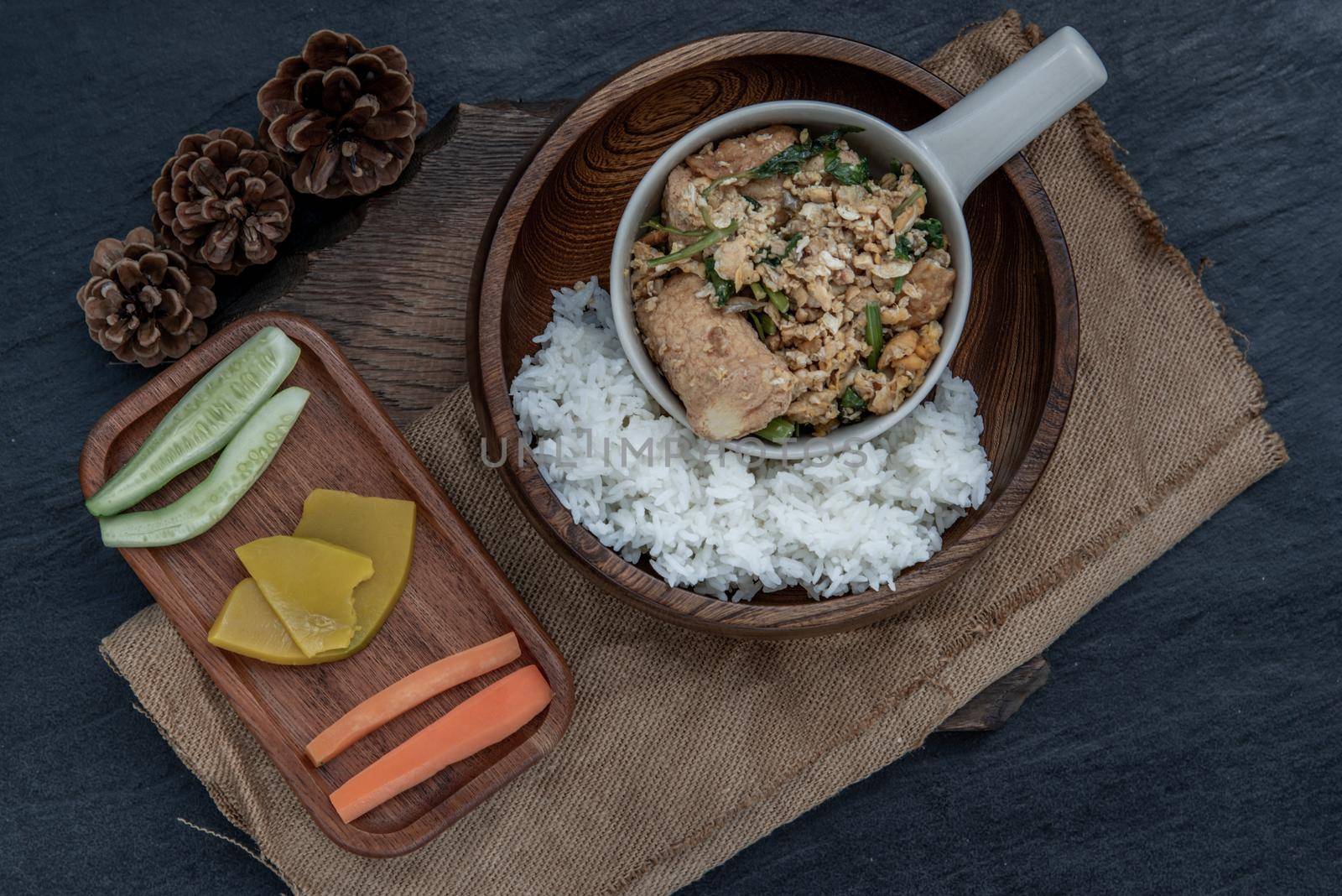 Thai food, Stir fried egg tofu with spring onion with Herbs vegetables served with steamed rice in wooden bowl, view from above.